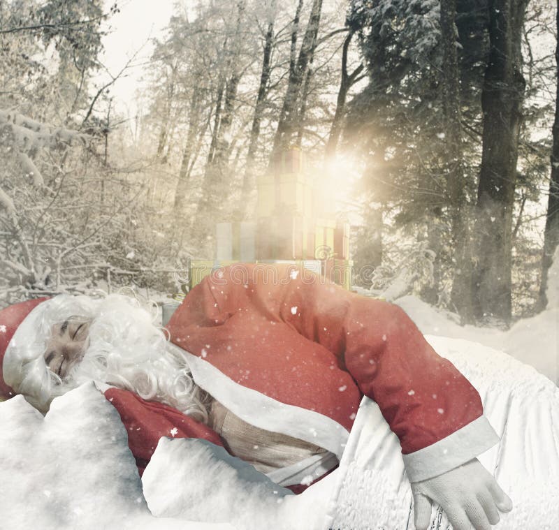 Le père noël dormant sur la neige devant des cadeaux à la forêt entourent image stock Le père noël dormant sur la neige devant des cadeaux à la forêt entourent image stock