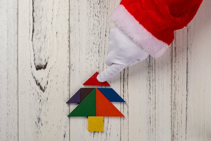 Le père noël finissant le dernier peu de l'arbre de Noël fait par tangram photo libre de droits Le père noël finissant le dernier peu de l'arbre de Noël fait par tangram photo libre de droits