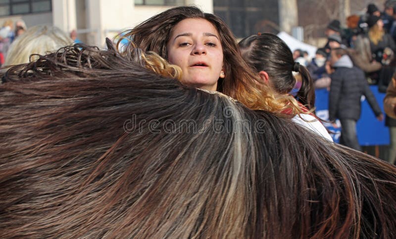 Le ragazze Kukeri, mummers realizzano i rituali per fare scappare i demoni durante il festival internazionale dei giochi di trave fotografia stock libera da diritti Le ragazze Kukeri, mummers realizzano i rituali per fare scappare i demoni durante il festival internazionale dei giochi di trave fotografia stock libera da diritti