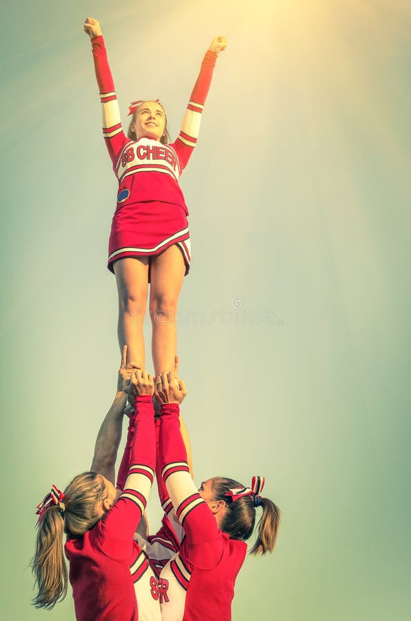 Cheerleaders in action on a vintage filtered look - Concept of unity and team sport - Training at college high school with young female teenagers. Cheerleaders in action on a vintage filtered look - Concept of unity and team sport - Training at college high school with young female teenagers