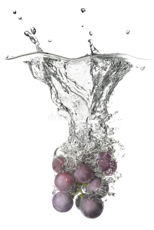Le raisin bleu a relâché dans l'eau avec l'éclaboussure photographie stock Le raisin bleu a relâché dans l'eau avec l'éclaboussure photographie stock