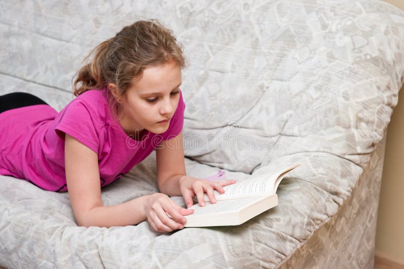 Le relevé de fille sur le sofa image stock Le relevé de fille sur le sofa image stock