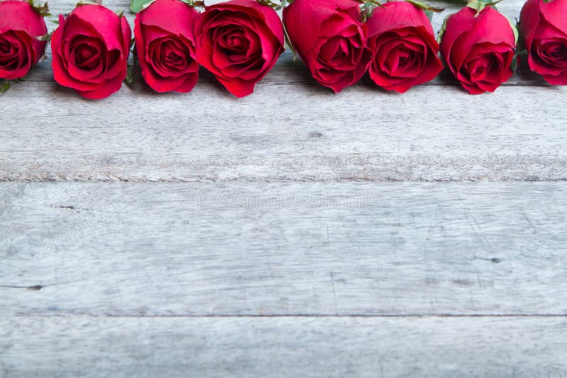 Le rose rosse sopra woonden il fondo Priorità bassa di giorno del biglietto di S fotografie stock Le rose rosse sopra woonden il fondo Priorità bassa di giorno del biglietto di S fotografie stock