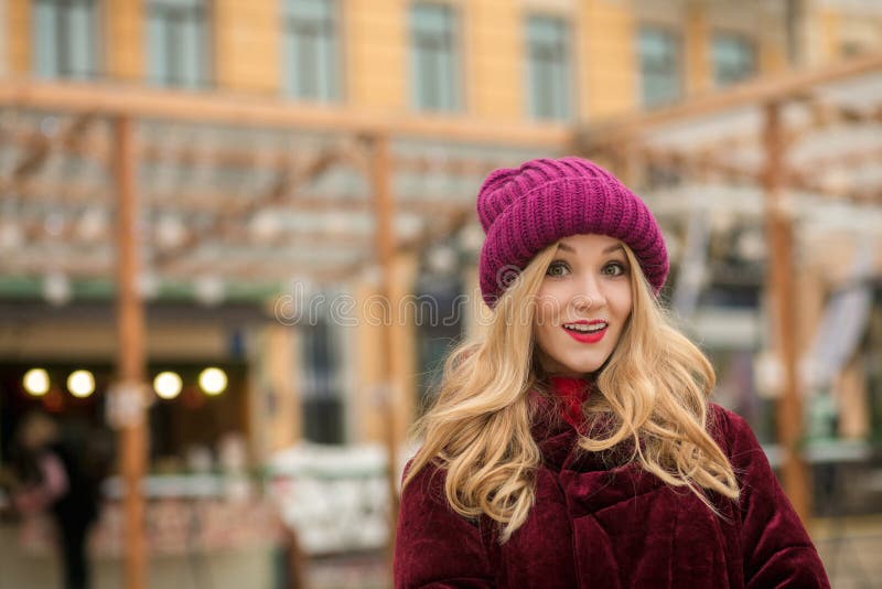 Le rouge de port étonné de jeune femme a tricoté le chapeau et le manteau d'hiver, p images libres de droits Le rouge de port étonné de jeune femme a tricoté le chapeau et le manteau d'hiver, p images libres de droits