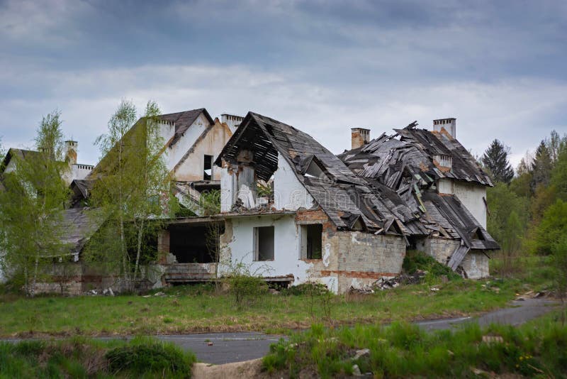 Le rovine di vecchia casa con mattoni a vista con un tetto di legno e gli alberi fotografie stock libere da diritti Le rovine di vecchia casa con mattoni a vista con un tetto di legno e gli alberi fotografie stock libere da diritti
