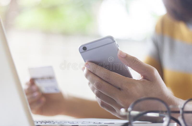 Le ` s de femmes d'affaires remet tenir un téléphone et une carte de crédit futés photo stock Le ` s de femmes d'affaires remet tenir un téléphone et une carte de crédit futés photo stock