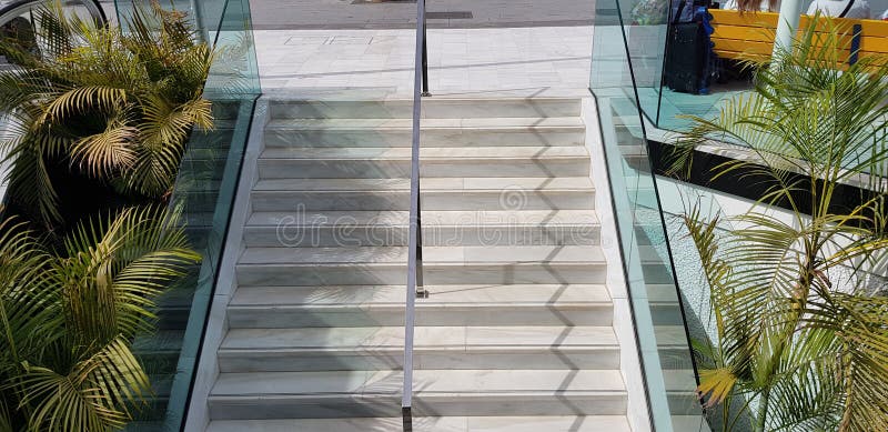 Le scala ed il cromo pubblici della scala metal il divisore del corrimano con le sezioni del lato degli occhiali di protezione immagini stock libere da diritti Le scala ed il cromo pubblici della scala metal il divisore del corrimano con le sezioni del lato degli occhiali di protezione immagini stock libere da diritti