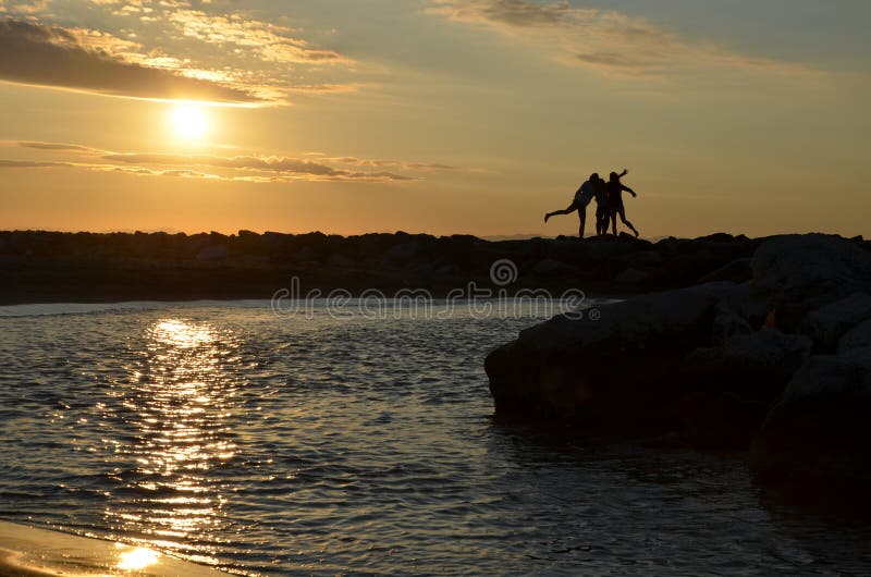 Le siluette delle donne da alba in mare fotografia stock libera da diritti Le siluette delle donne da alba in mare fotografia stock libera da diritti