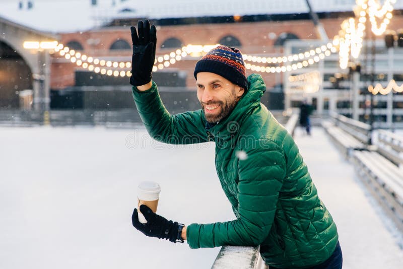 Le skäggiga mandrinkar takeaway kaffe, vågor med handen till arkivbild Le skäggiga mandrinkar takeaway kaffe, vågor med handen till arkivbild