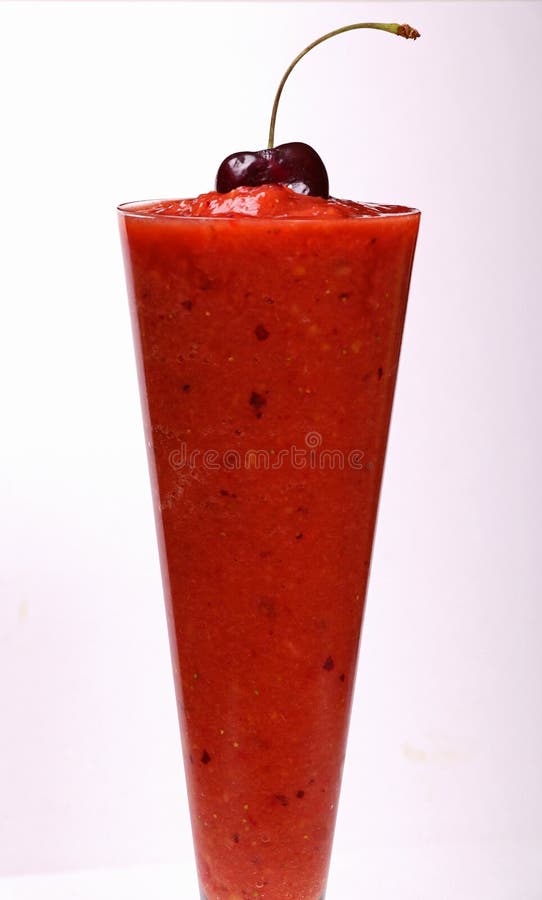 Le smoothie surgelé de fraise a complété avec une cerise photo stock Le smoothie surgelé de fraise a complété avec une cerise photo stock
