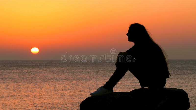 Le soleil de observation de silhouette de femme au lever de soleil banque de vidéos