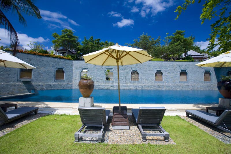 Le soleil de ressource de poolside de fainéants d'hôtel photo libre de droits