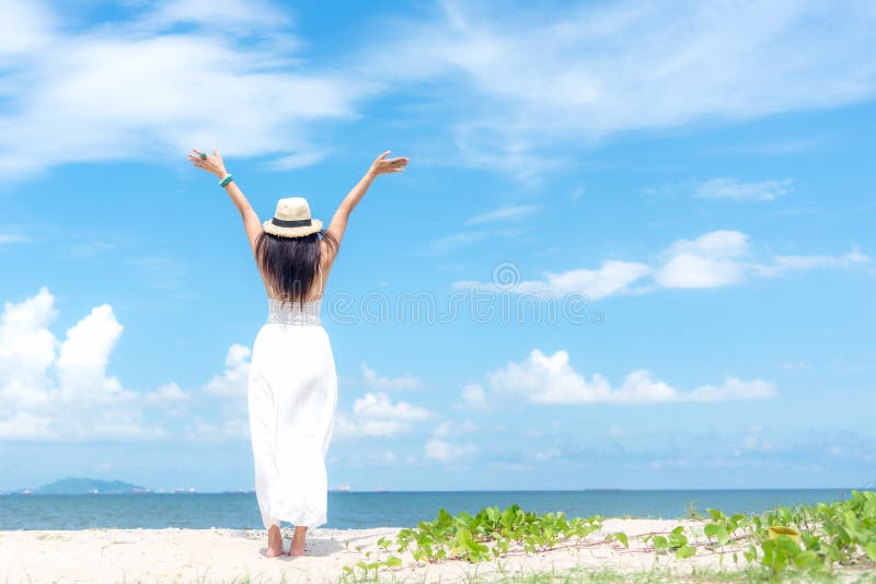 Le sommar för klänning för mode för kvinna som bärande vit går på den sandiga havstranden, härlig bakgrund för blå himmel Lycklig royaltyfria bilder
