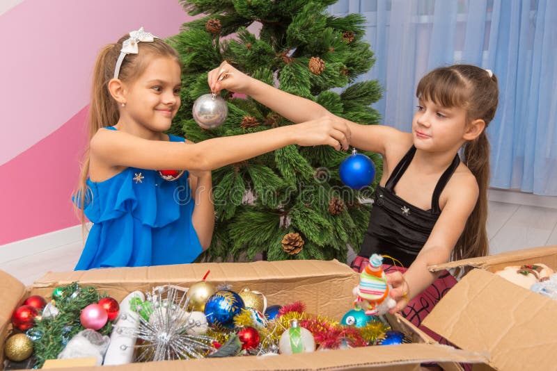 Le sorelle si mostrano le palle di Natale fotografie stock libere da diritti Le sorelle si mostrano le palle di Natale fotografie stock libere da diritti