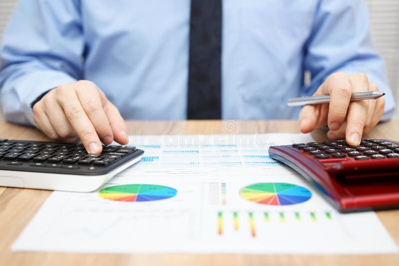 Le spécialiste financier travaille avec la calculatrice et l'ordinateur à photo libre de droits Le spécialiste financier travaille avec la calculatrice et l'ordinateur à photo libre de droits