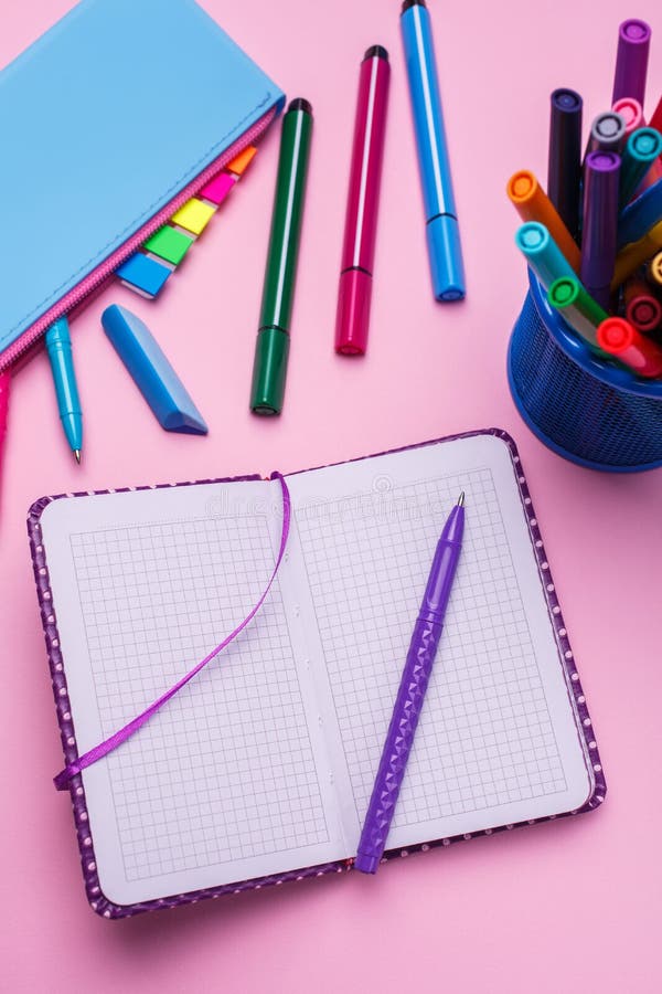 Le stylo est sur un carnet ouvert, à côté d'un cas de correction sur un fond rose images libres de droits Le stylo est sur un carnet ouvert, à côté d'un cas de correction sur un fond rose images libres de droits
