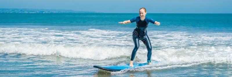 Le surfer joyeux de débutante de jeune femme avec le ressac bleu a l'amusement sur de petites vagues de mer Mode de vie actif de photos libres de droits