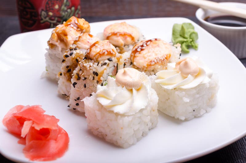 Le sushi coupé roule sur un plateau avec du gingembre et le wasabi images stock Le sushi coupé roule sur un plateau avec du gingembre et le wasabi images stock