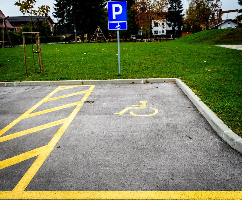 Le symbole de fauteuil roulant dans un parking marque le parking handicapé image libre de droits Le symbole de fauteuil roulant dans un parking marque le parking handicapé image libre de droits