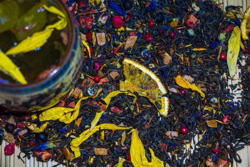 Le thé vert parfumé avec les pétales jaunes de fleur est brassé dans une tasse avec les ornements chinois de culture image libre de droits Le thé vert parfumé avec les pétales jaunes de fleur est brassé dans une tasse avec les ornements chinois de culture image libre de droits