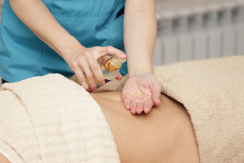 Le thérapeute de massage applique l'huile pour le massage photos stock Le thérapeute de massage applique l'huile pour le massage photos stock