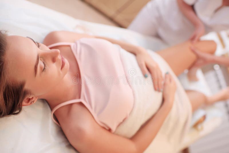 Le thérapeute de massage fait un massage de pied pour une femme enceinte image libre de droits Le thérapeute de massage fait un massage de pied pour une femme enceinte image libre de droits