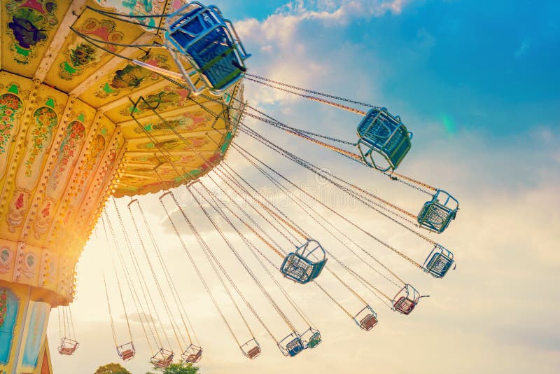 Le tour de carrousel tourne rapidement dans le ciel au coucher du soleil - un carou de oscillation image libre de droits Le tour de carrousel tourne rapidement dans le ciel au coucher du soleil - un carou de oscillation image libre de droits