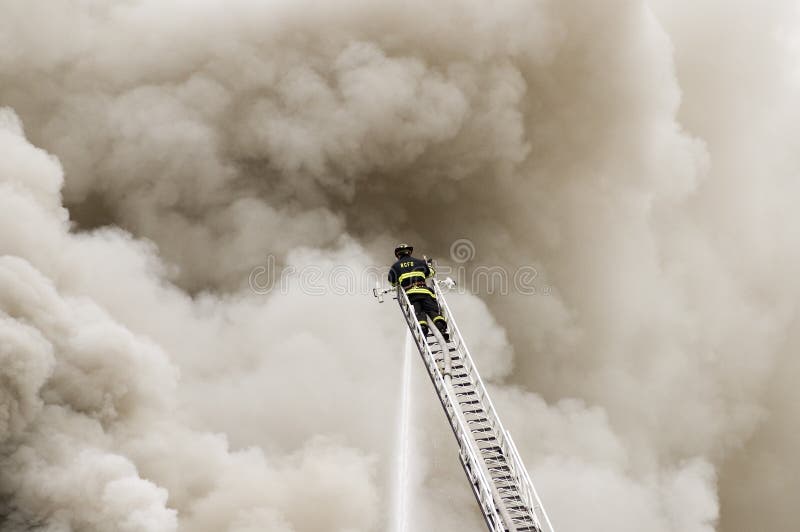 One fireman battling a blaze from the top of the ladder. One fireman battling a blaze from the top of the ladder.