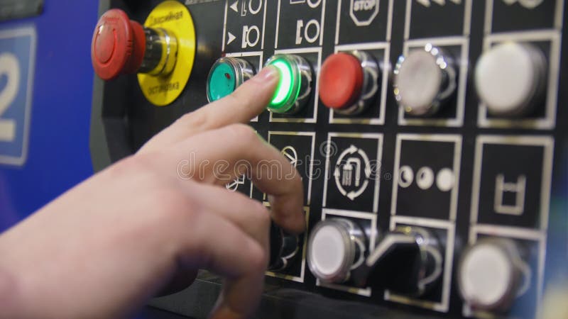 Le travailleur appuie sur le bouton sur le panneau de commande en plan rapproché d'atelier banque de vidéos