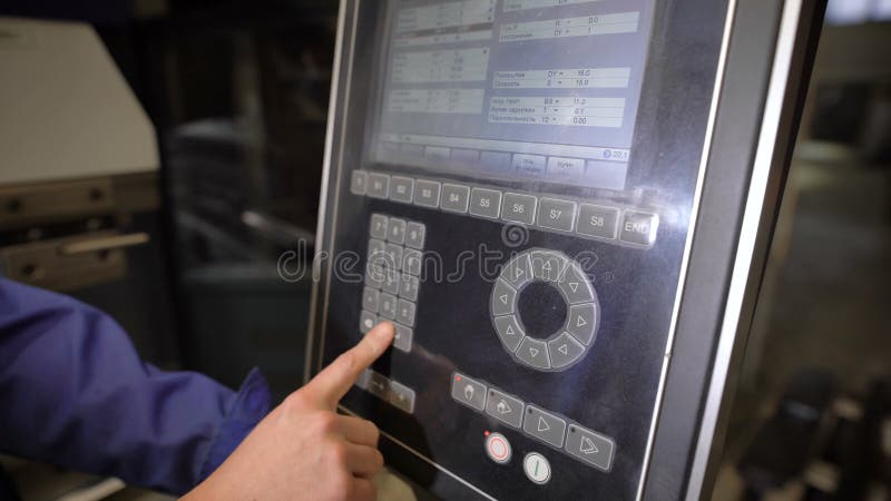 Le travailleur appuie sur des boutons du panneau de la machine-outil avec la commande programmée numérique L'ingénieur configure clips vidéos