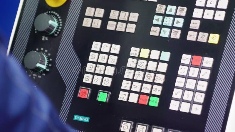 Le travailleur appuie sur des boutons sur le panneau de configuration de commande numérique dans l'atelier banque de vidéos