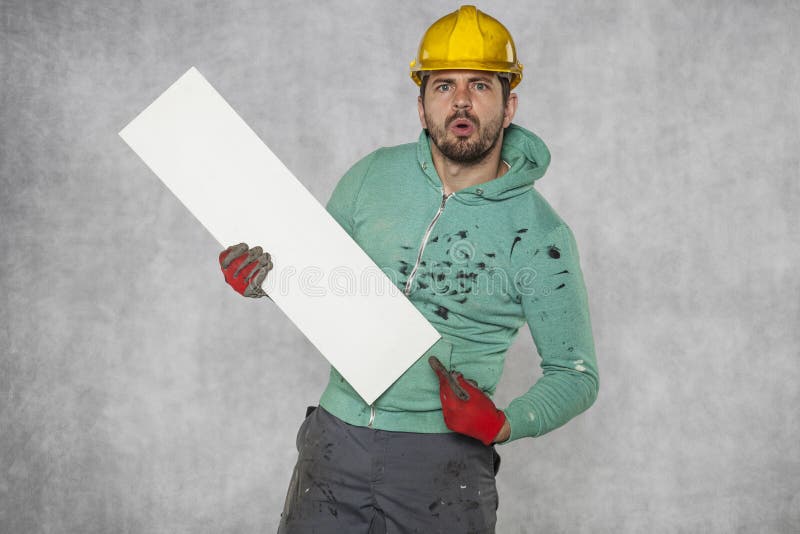 Le travailleur dans le casque montre l'endroit pour la publicité images stock Le travailleur dans le casque montre l'endroit pour la publicité images stock