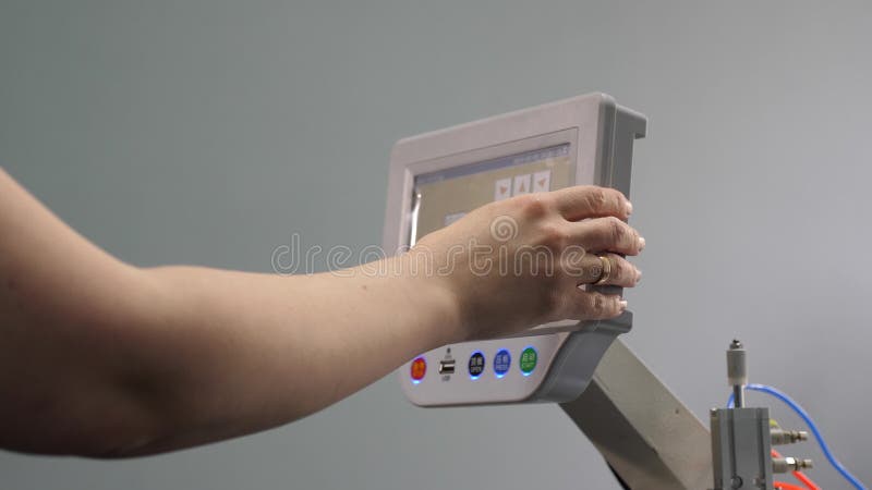 Le travailleur programme une machine à coudre avec un CNC à l'aide d'un ordinateur tablette rapprochement L'opérateur configure l banque de vidéos