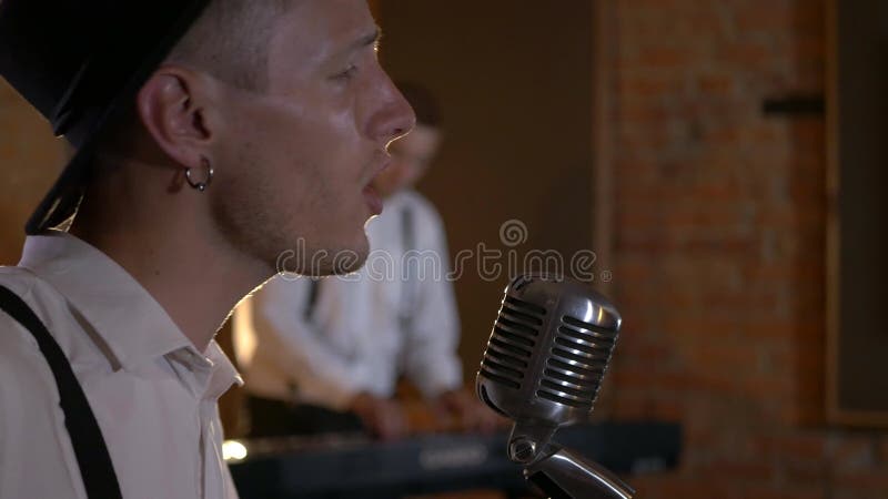 Le type chante et joue de la guitare au studio. le groupe musical joue au restaurant. la nuit est une lumière romantique.