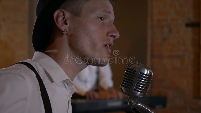 Le type chante et joue de la guitare au studio. le groupe musical joue au restaurant. la nuit est une lumière romantique.