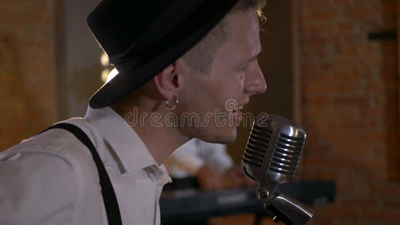 Le type chante et joue de la guitare au studio. le groupe musical joue au restaurant. la nuit est une lumière romantique.