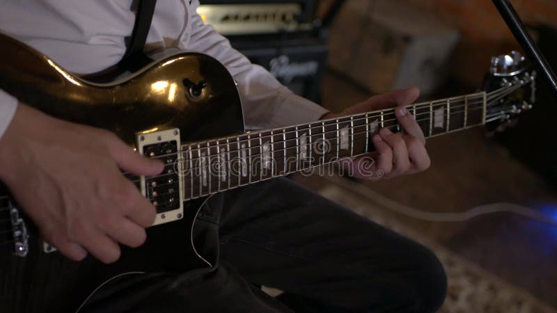 Le type chante et joue de la guitare au studio. le groupe musical joue au restaurant. la nuit est une lumière romantique.