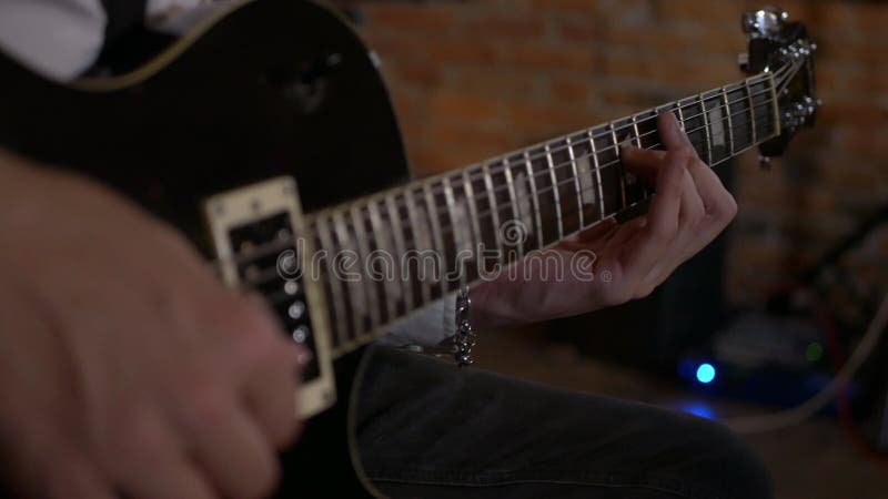 Le type chante et joue de la guitare au studio. le groupe musical joue au restaurant. la nuit est une lumière romantique.