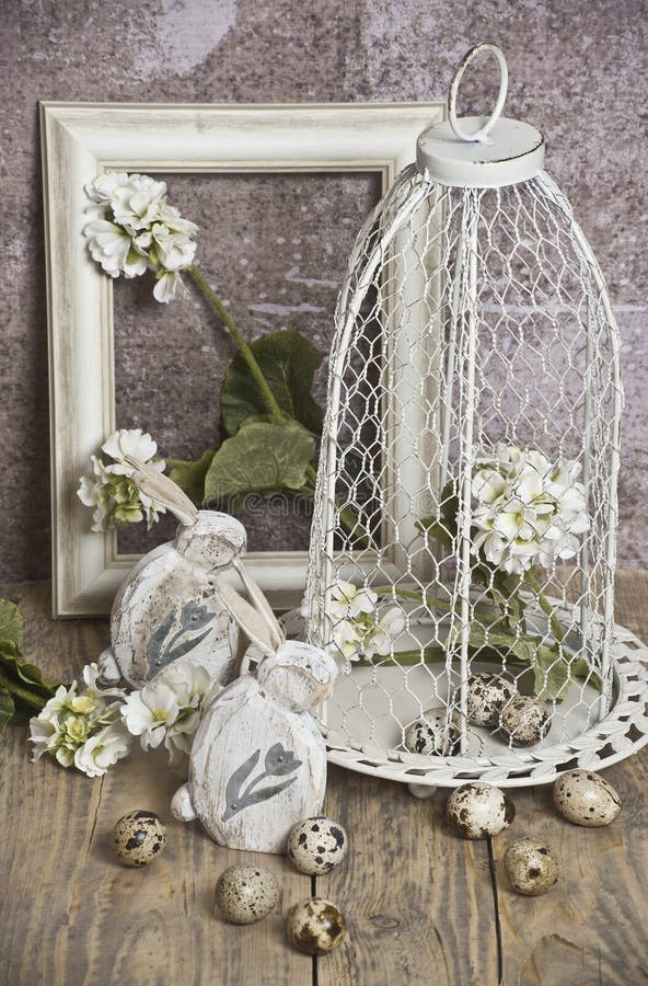 Le uova di Pasqua in una gabbia, balzano fiori bianchi, le uova di quaglia, coniglietti bianchi fotografia stock Le uova di Pasqua in una gabbia, balzano fiori bianchi, le uova di quaglia, coniglietti bianchi fotografia stock