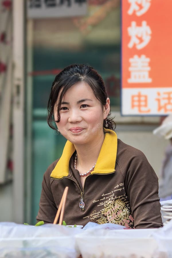 Le vendeur féminin vend la nourriture de rue sur un marché local, Pékin, Chine image stock Le vendeur féminin vend la nourriture de rue sur un marché local, Pékin, Chine image stock