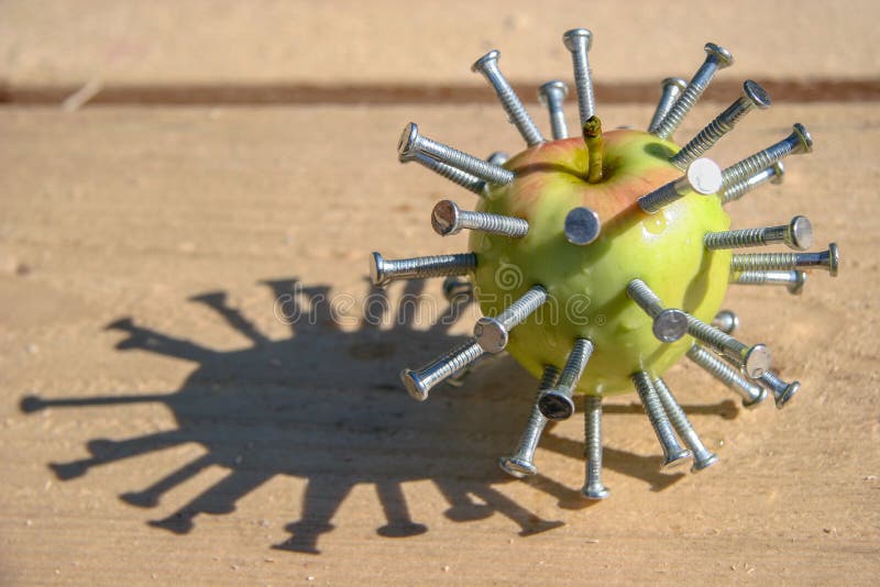 Le vert avec la pomme rouge avec les clous coincés se trouve sur une barre en bois un jour ensoleillé Abstraction Hellraiser images libres de droits Le vert avec la pomme rouge avec les clous coincés se trouve sur une barre en bois un jour ensoleillé Abstraction Hellraiser images libres de droits
