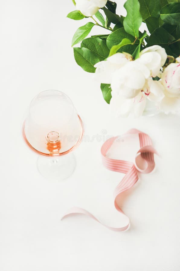 Le vin de Rose en verre, ruban décoratif rose, pivoine fleurit images libres de droits Le vin de Rose en verre, ruban décoratif rose, pivoine fleurit images libres de droits