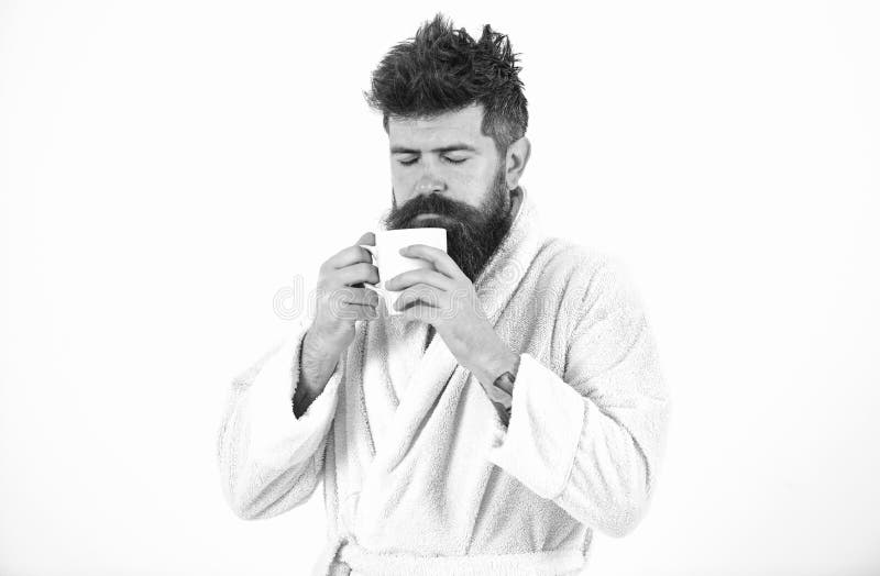 Le visage assoupi et somnolent macho boit du café dans le matin appréciant l'arome L'homme avec la barbe et les cheveux en désord image stock Le visage assoupi et somnolent macho boit du café dans le matin appréciant l'arome L'homme avec la barbe et les cheveux en désord image stock