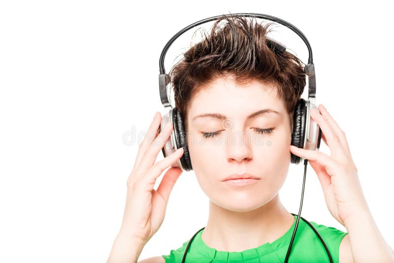 Le visage du ` s de femme avec des yeux a fermé écouter la musique sur un blanc image stock Le visage du ` s de femme avec des yeux a fermé écouter la musique sur un blanc image stock