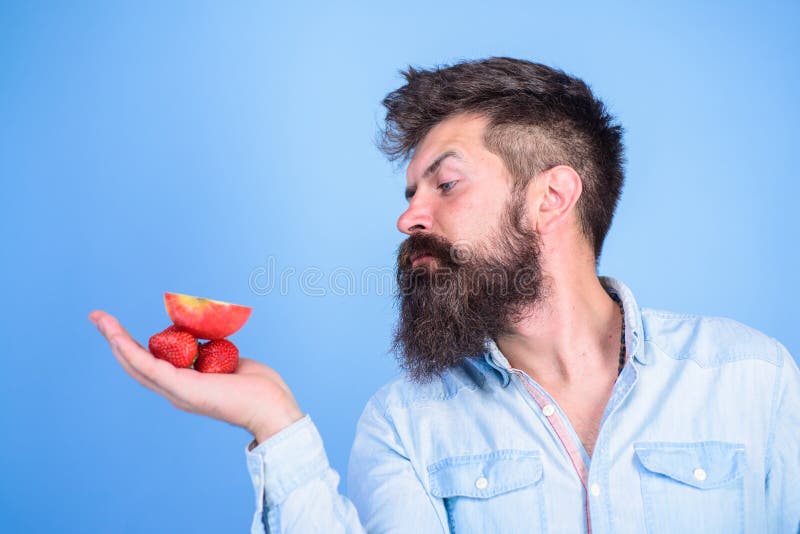 Le visage strict d'homme avec la barbe offre les festins organiques Je prends des festins pour vous L'homme offre d'essayer les f photo stock Le visage strict d'homme avec la barbe offre les festins organiques Je prends des festins pour vous L'homme offre d'essayer les f photo stock