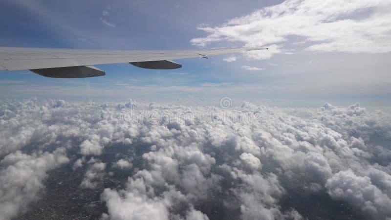 Le vol d'avion au-dessus des nuages au ciel bleu, fin plate d'aile