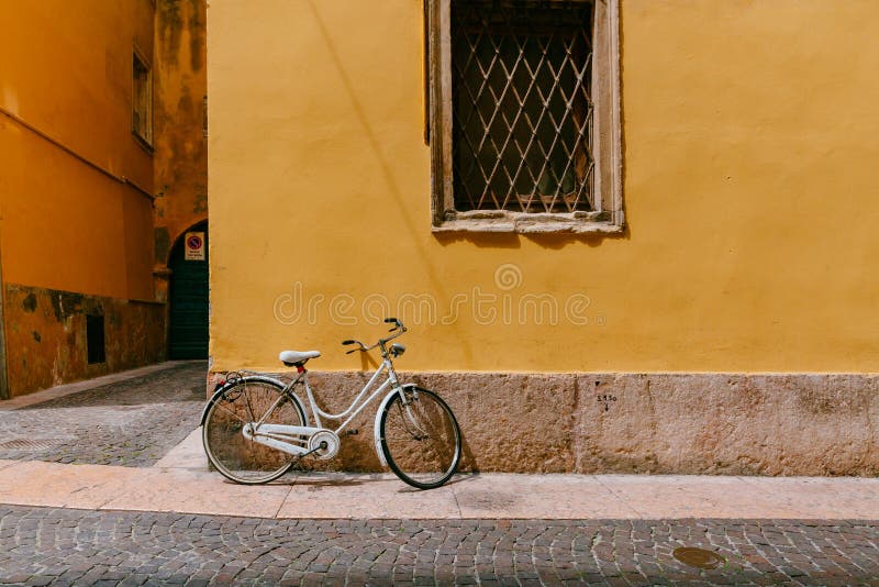 Le vélo blanc a garé le mur jaune d'agaisnt dans la rue de Vérone, Italie photo libre de droits Le vélo blanc a garé le mur jaune d'agaisnt dans la rue de Vérone, Italie photo libre de droits