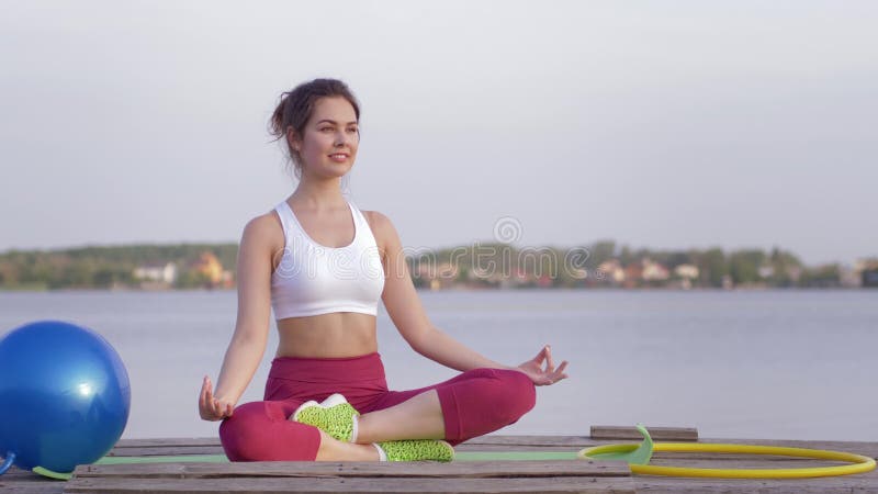 Le yoga détendant, jeune fille attirante de yogi en position de lotus médite et enchante les calmnes spirituels sur la nature