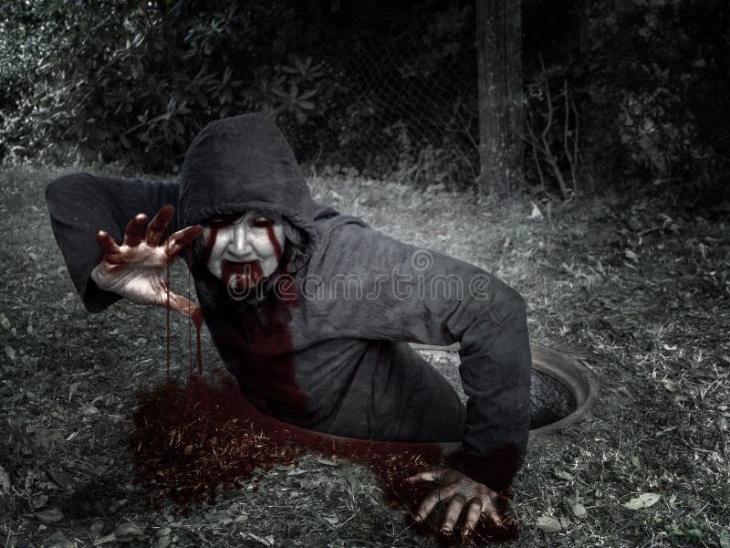 Le zombi ensanglanté s'élève hors de l'égout bien image stock Le zombi ensanglanté s'élève hors de l'égout bien image stock