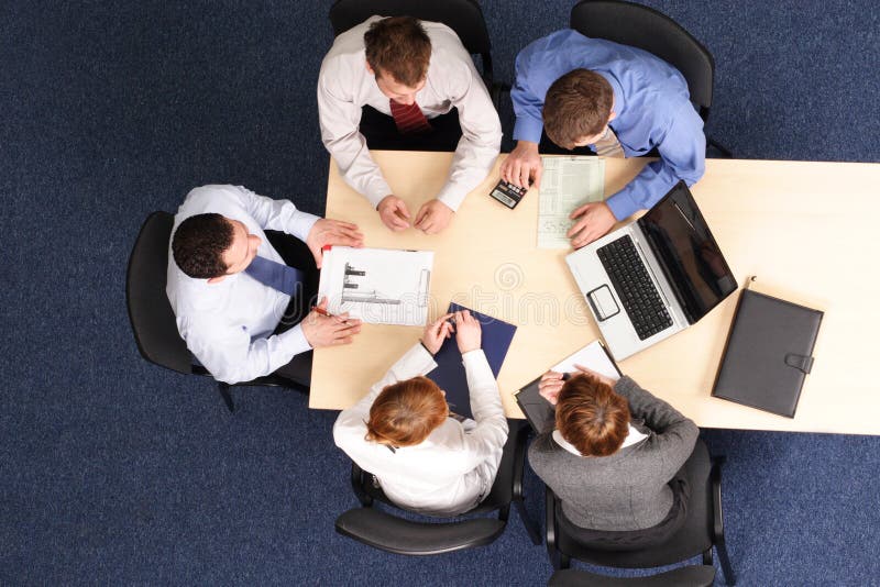 Businesspeople zhromaždili okolo stola na stretnutie, brainstorming.